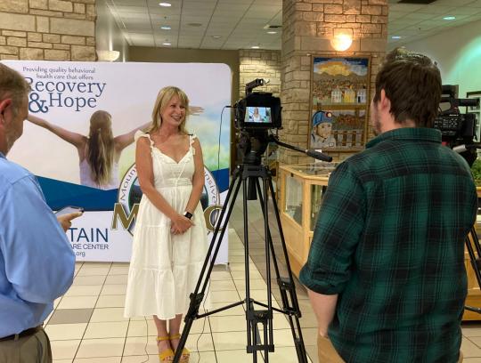 Woman being interviewed in a white dress